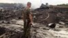 An armed pro-Russian separatist stands at the site of the Malaysia Airlines Boeing 777 plane crash in Ukraine's eastern Donetsk region on July 17.