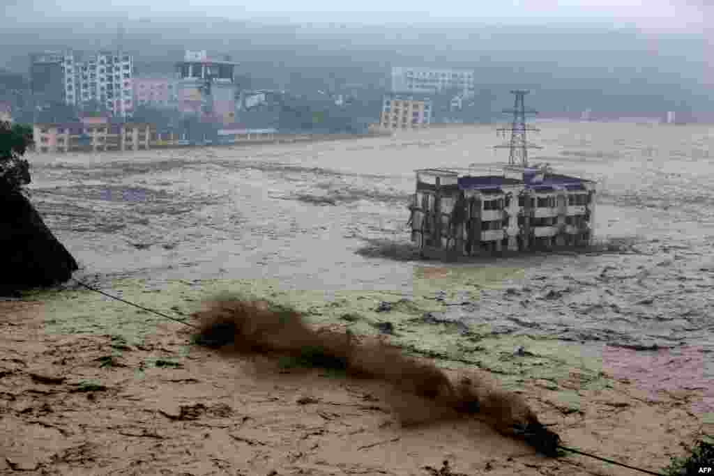Heavy floodwaters sweep through Beichuan in southwest China&#39;s Sichuan Province, as rainstorms sweeping across parts of China have affected millions, causing landslides and disabling transportation. (AFP)