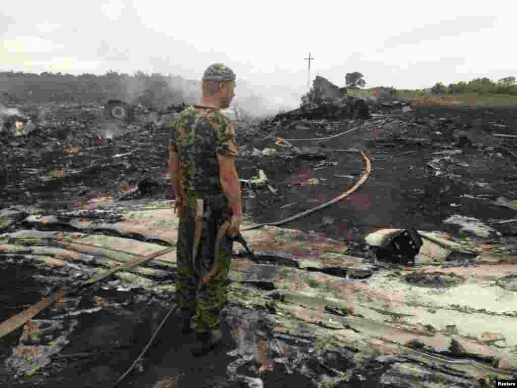 An armed pro-Russian separatist stands at one of the main crash sites on July 17.