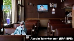 IRAN -- An Iranian woman enjoys her food at a restaurant in Tehran, May 26, 2020