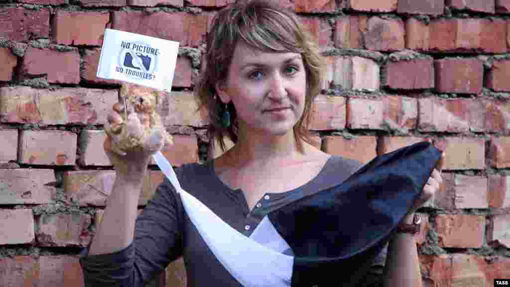 Belarusian photojournalist Yulya Darashkevich poses with a teddy bear at a Minsk court building in support of arrested photographer Anton Surapin, who took photos of teddy bears dropped by a plane during an opposition stunt. (ITAR-TASS/Vadim Rymakov)