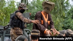 Forces with Afghanistan's National Directorate of Security (NDS) escort alleged Taliban and Islamic State (IS) fighters after they are presented to media in Jalalabad on May 23.
