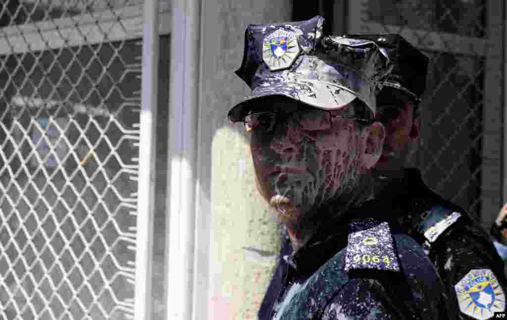 A policeman is covered in paint during clashes with demonstrators in Pristina who were against the ratification of an agreement with Serbia. Protesters from a radical nationalist movement attempted to block the entrance to Kosovo's parliament to prevent deputies from ratifying an agreement that would normalize ties with Serbia. (AFP/Armend Nimani)