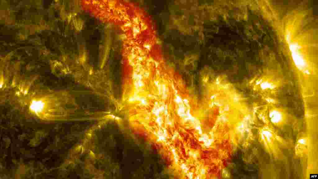 Камери NASA змогли зафіксувати, як нитки сонячної плазми прориваються крізь оболонку сонця. Завдяки розбіжним ниткам (червоні – плазма температурою близько 50 тисяч градусів, жовті нитки – близько 560 тисяч градусів) можна спостерігати гігантські магнітні петлі, що створюють магнітне поле, відгомін якого досягає Землі (AFP PHOTO / NASA/ SOLAR DYNAMICS OBSERVATORY)