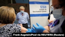 Премьер-министр Борис Джонсон присутствует при первой вакцинации от коронавируса в лондонском госпитале. 8 декабря 2020