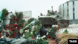 Flori în memoria celor uciși de trupele speciale sovietice în fața Televiziunii din Vilnius, păzită de un TAB sovietic, 17 ianuarie 1991