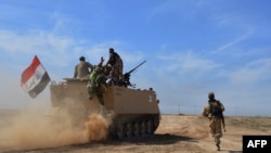 Iraq -- Iraqi pro-government forces sit on armoured personnel carrier (APC) driving near the Al-Alam village, northeast of the multi-ethnic city of Tikrit, March 8, 2015