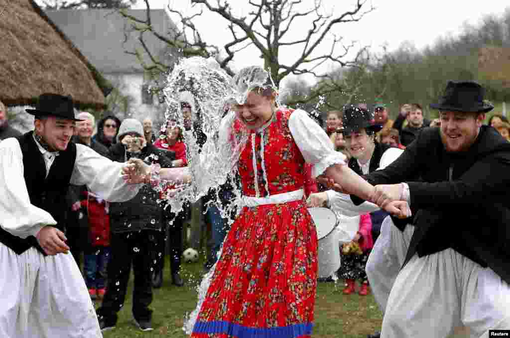 Men throw water on a woman as part of traditional Easter celebrations in Szenna, Hungary. (Reuters/Laszlo Balogh)