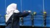 A woman puts a flower on a truck carrying the remains of people killed in Srebrenica in 1995 as it drives through Sarajevo.