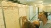 Stockbrokers write prices on a board at the Iraqi Stock Exchange