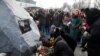 People lay flowers during a foundation stone laying ceremony for a future memorial site to the people killed in a plane shot down in Iran in January, at the Boryspil International Airport outside Kyiv, February, 17, 2020