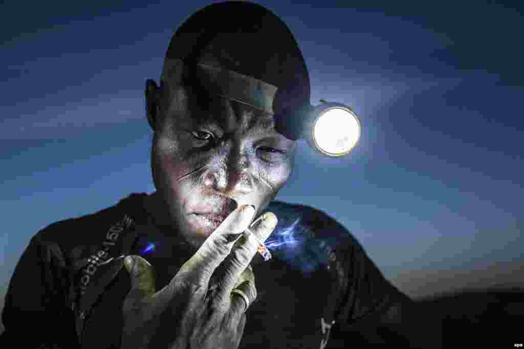 Second Prize Singles in the People category was won by Slovenian photographer Matjaz Krivic. The picture shows a mine worker taking a smoke break before going back into the pit in Bani, Burkina Faso. (November 20, 2015)