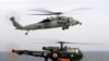 An US Navy MH-60 R/S Seahawk helicopter flies over a French Navy Alouette III as it lands on the flight deck of the French Navy aicraft carrier Charles de Gaulle in the Gulf of Oman. File photo