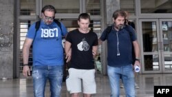 Russian Aleksandr Vinnik (center) is escorted by police as he arrives at a courthouse in Thessaloniki on July 26, 2017.