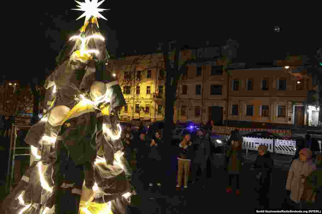 Люди фотографують «Ялинку світла» – символічну інсталяцію на честь енергетиків біля одного із закладів у Києві