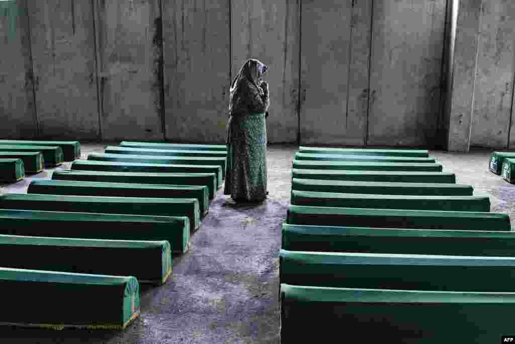 A Bosnian women mourns by the coffin of her relative in Srebrenica, where 136 bodies found in mass grave sites in eastern Bosnia will be reburied on the 20th anniversary of the Srebrenica massacre. Nearly 8,000 men and boys from the enclave were captured and systematically killed by Bosnian Serb forces in the days after the fall of Srebrenica on July 11, 1995. (AFP/Dimitar Dilkoff)