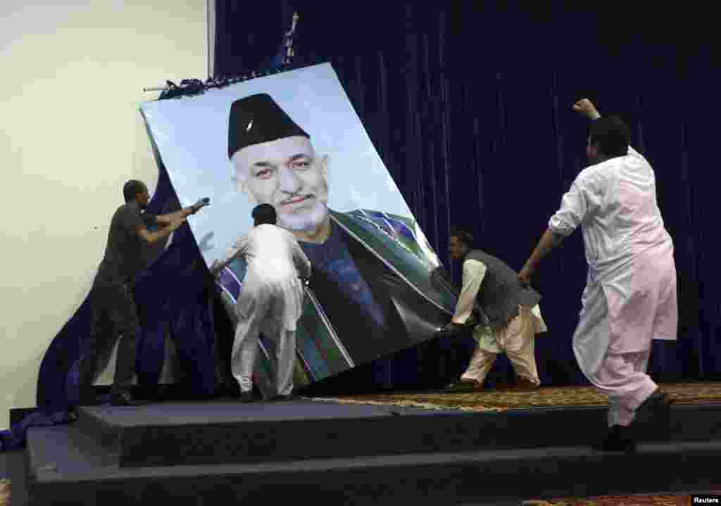 Президентская кампания 2014 года.&nbsp;Разгневанные сторонники Абдуллы Абдуллы снимают большой портрет Карзая перед акцией протеста в Кабуле 8 июля. Абдулла заявил, что Карзай (который не мог по конституции&nbsp;избираться в третий раз)&nbsp;использовал административный ресурс для поддержки во втором туре его соперника, Ашрафа Гани. 21 сентября&nbsp;Абдулла и Гани подписали соглашение о формировании правительства национального единства и договорились&nbsp;о разделении полномочий: должность президента перейдёт Гани, а Абдулла займёт высокий пост в системе исполнительной власти. 