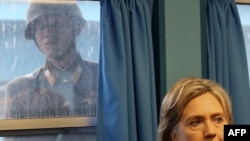 Un soldat nord-corean privind-o printr-o fereastră pe secretarul de stat Hillary Clinton la Panmunjon în zona demilitarizată