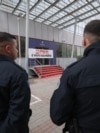 Pjesëtarë të Policisë së Kosovës duke shikuar hyrjen e ndërtesës së Qeverisë së Kosovës, në Prishtinë, më 26 tetor, pasi disa aktiviste vendosën një banderolë dhe hodhën ngjyrë të kuqe në shenjë proteste pas vrasjes së një gruaje në Pejë.