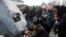 People lay flowers during a foundation stone laying ceremony for a future memorial site to the people killed in a plane shot down in Iran in January, at the Boryspil International Airport outside Kyiv, February, 17, 2020