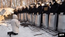 Жінка стоїть на колінах перед правоохоронцями на Грушевського, Київ, 24 січня 2014 року