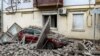 A car lies under debris outside a building damaged as a result of a Russian air strike on Kherson on February 2.