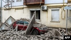 A car lies under debris outside a building damaged as a result of a Russian air strike on Kherson on February 2.