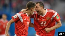 Russian midfielder Roman Zobnin (left) and forward Artem Dzyuba celebrate the team's opening goal against Egypt in St. Petersburg on June 19.