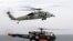 An US Navy MH-60 R/S Seahawk helicopter flies over a French Navy Alouette III as it lands on the flight deck of the French Navy aicraft carrier Charles de Gaulle in the Gulf of Oman. File photo