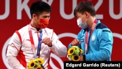 Казахстанец Игорь Сон и китайский тяжелоатлет Ли Фабинь (слева) на церемонии награждения