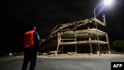 Un polițist lângă o clădire prăbușită la Valencia, Venezuela, pe 24 iunie 2026.