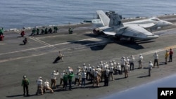 A handout photograph released by the US Navy on February 8 shows observers including US envoys Steve Witkoff and Jared Kushner as they watch operations on the flight deck of the USS Abraham Lincoln aircraft carrier. 