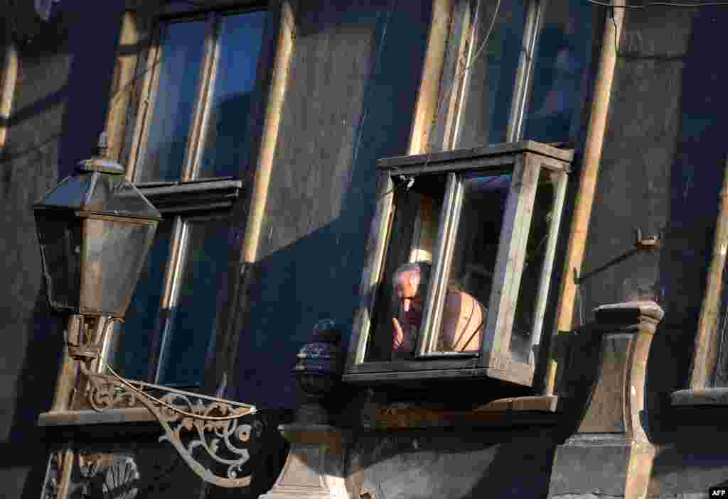 Сталы сэрбскі мужчына гледзіць на вуліцу, дзе адбываецца штогадовы музычны фэстываль у Новым Садзе