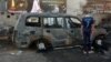 A boy inspects a burn-out vehicle the day after a bomb attack near a funeral tent in the Sadr City district of Baghdad, which killed several people on September 21. There have been three deadly attacks on funerals in as many days in Iraq. 