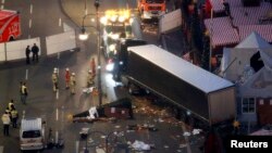 Тягач вытаскивает грузовик, врезавшийся в рождественский рынок в Берлине, в районе Курфюрстендамм, 20 декабря 2016 года 
