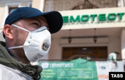 A man in a protective mask at the entrance to one of the departments of the laboratory "Hemotest" in Simferopol, annexed Crimea