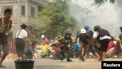 На кадре из видео, полученном агентством Reuters, протестующие укрываются во время столкновений с силами безопасности в мьянманском городе Монива, 21 марта 2021 года. 