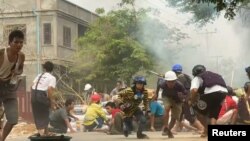  Reuters агенттігінің қолына видеодан алынған бұл кадрде қауіпсіздік күштерімен қақтығысқа түскен наразылар пана іздеп жатыр. Монива қаласы, Мьянма. 21 наурыз, 2021 жыл. 