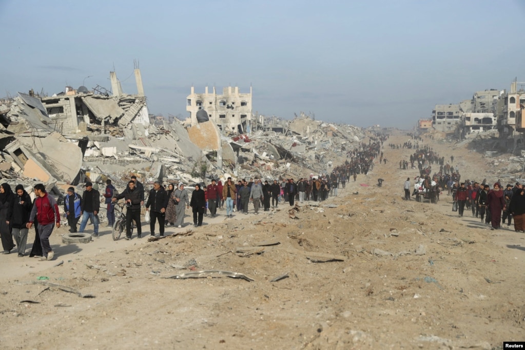 Palestinezët e zhvendosur duke u kthyer në shtëpitë e tyre ndërsa ecin mes rrënojave.&nbsp;