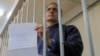 Paul Whelan holds up his note from inside a defendants cage before a court hearing on extending his pretrial detention in Moscow on October 24.
