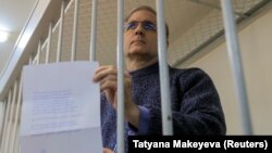 Paul Whelan holds up his note from inside a defendants cage before a court hearing on extending his pretrial detention in Moscow on October 24.