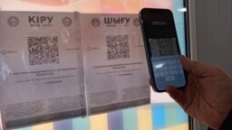 Көпшілік қоғамдық орынға кіру үшін Ashyq қосымшасының көмегімен смартфонға QR-кодты түсіріп тұрған адам. Көрнекі сурет.