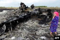 Женщина на обломках малайзийского самолета близ села Грабово Донецкой области Украины. 19 июля 2014 года.