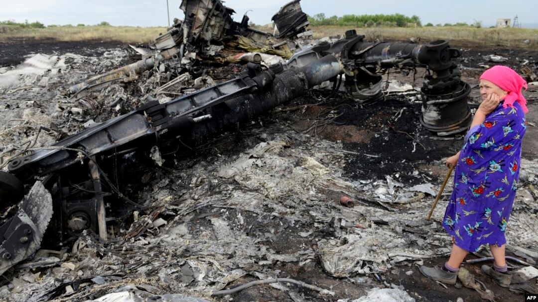 A local resident stands amid wreckage at the crash site of a Malaysia Airlines plane, which was shot down over eastern Ukraine last year, killing all 298 people on board.