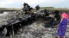 Lokalna stanovnica stoji među olupinama na mjestu nesreće MH17, 19. jula 2014. (Foto: AFP)