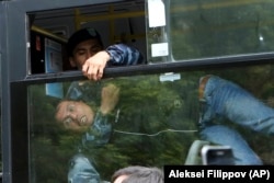 A detained demonstrator, seen in a police bus, struggles during an anti-government protest in Nur-Sultan on June 9.