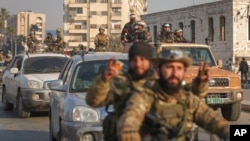 Syrian rebel fighters ride along the streets in the aftermath of the opposition's takeover of the city of Hama on December 6. 