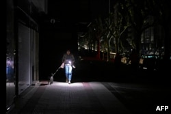 Vigo, Spania, 28 aprilie. O femeie își luminează drumul cu lanterna telefonului.