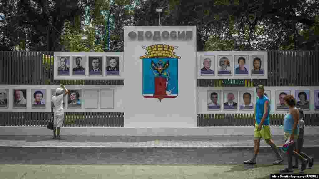 Чоловік розглядає «Дошку пошани», яку відкрили напередодні в Феодосії 