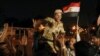 A soldier cheers with protesters opposed to Egyptian President Muhammad Morsi as they celebrate in front of the Republican Guard headquarters in Cairo after Morsi was deposed late on July 3. 
